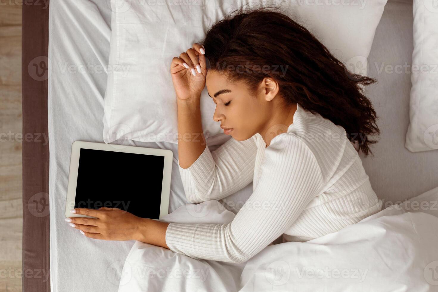 Gadget Addiction Concept. Above Top High Angle View Of African American Woman Sleeping Holding Digital Tablet Resting In Bed At Home. Always In Touch, Busy And Stressed Modern Life photo