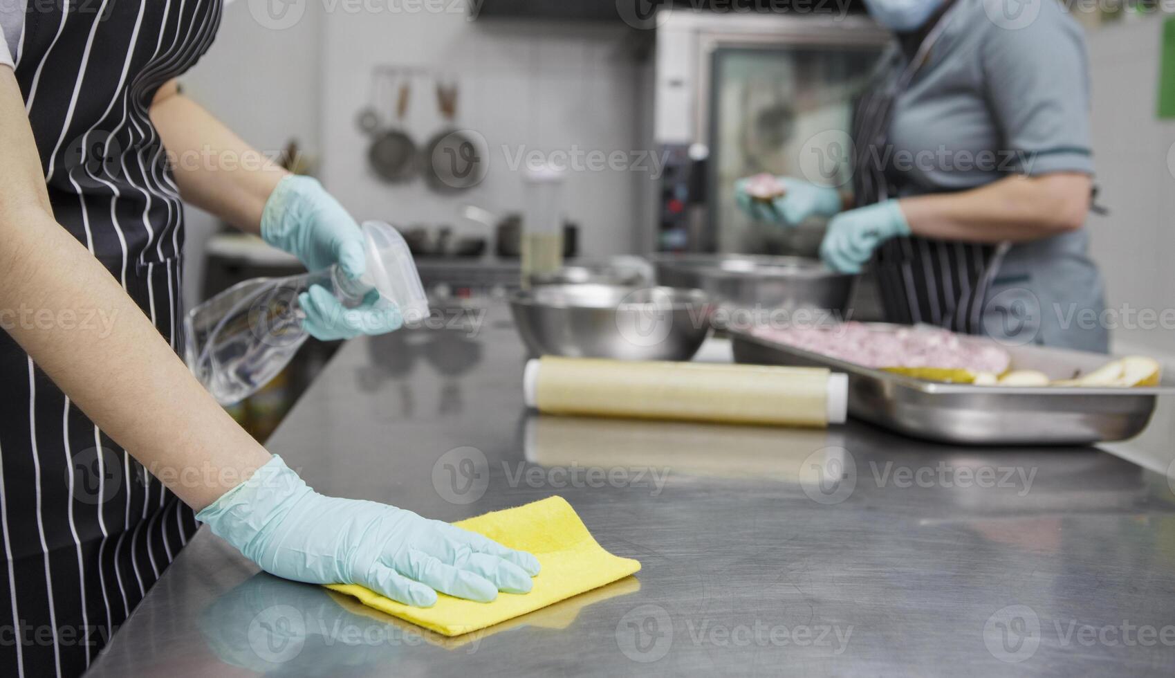 Coronavirus preventive measures. Woman disinfecting and cleaning kitchen table after cooking, panorama, copy space photo