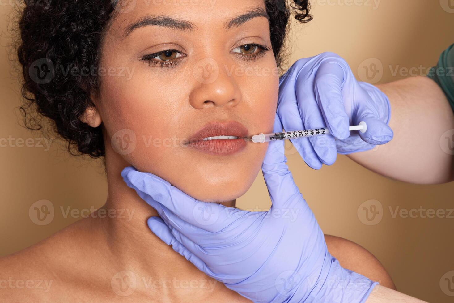 A woman sits in a clinic as a skincare professional administers a lip enhancement treatment using a syringe. The atmosphere is calm and focused, emphasizing beauty care. photo