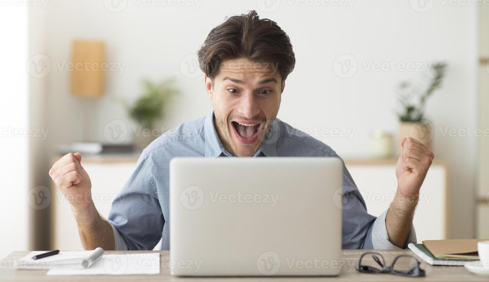 Luck And Win. Man Celebrating His Victory At Laptop Shaking Fists And Shouting Joyfully In Office photo