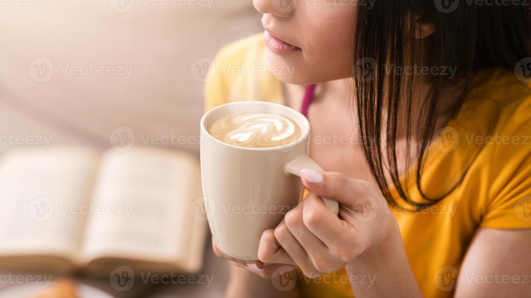 Closeup view of millennial girl with cup of fresh coffee spending lazy time at home, copy space photo