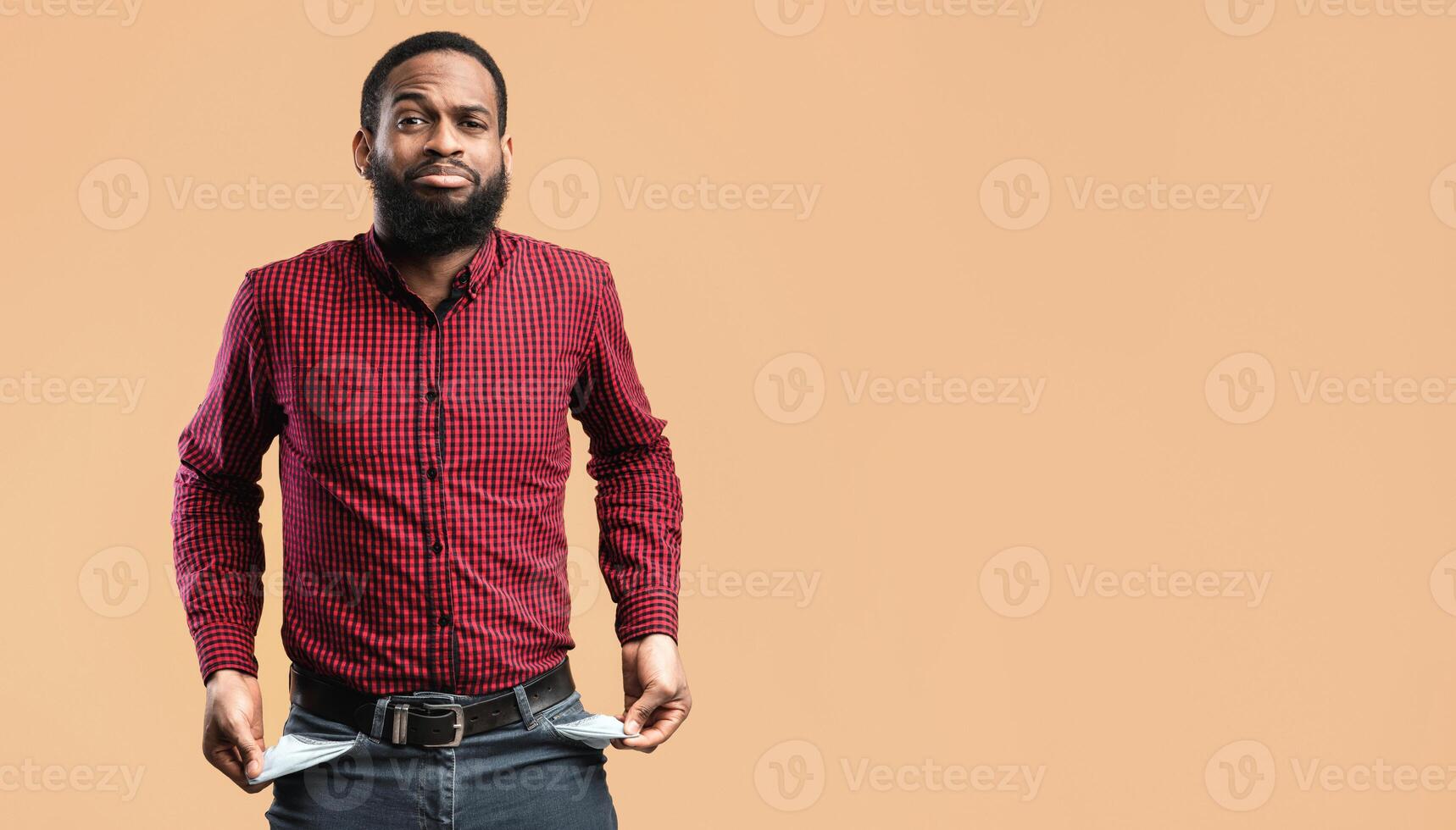 Poverty And Absence Of Money Concept. Unemployed sad black man showing empty pockets, isolated on yellow studio wall photo