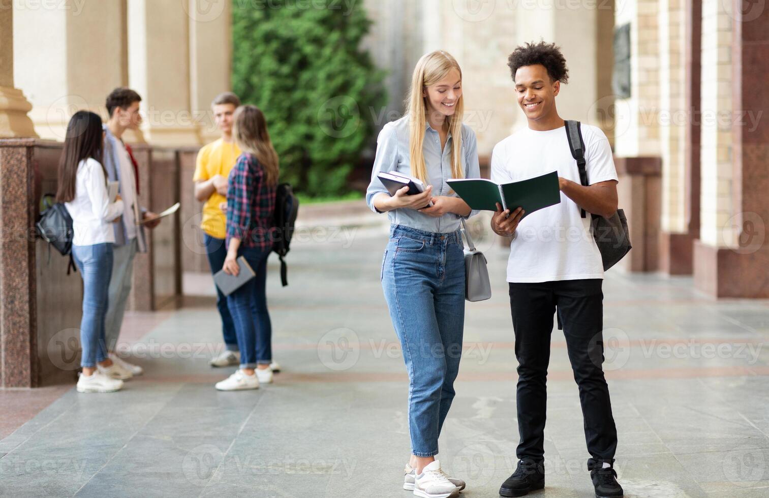 Teens preparing for classes, studying with books in university campus outdoors photo