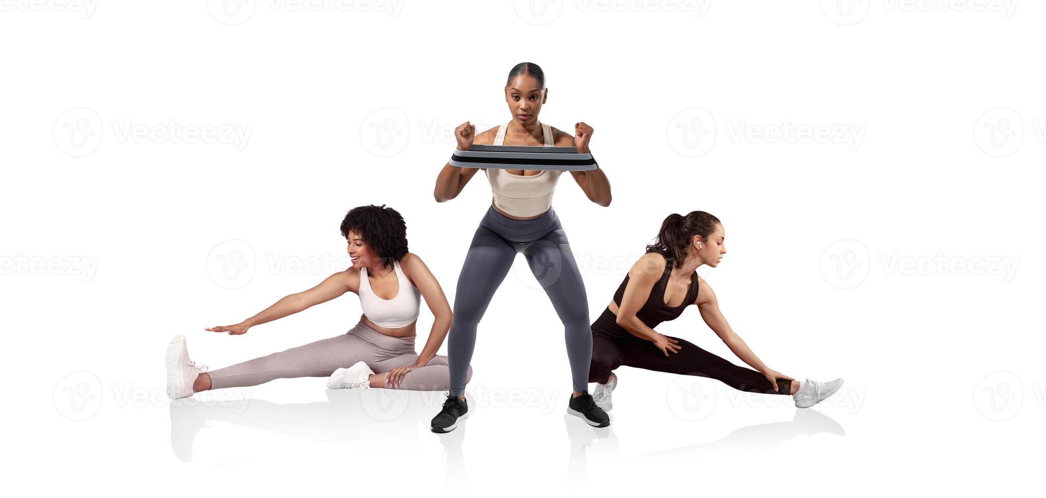 Three women participate in a fitness session, with one performing squats while holding a weight and the others stretching. The modern studio environment is bright and motivational. photo