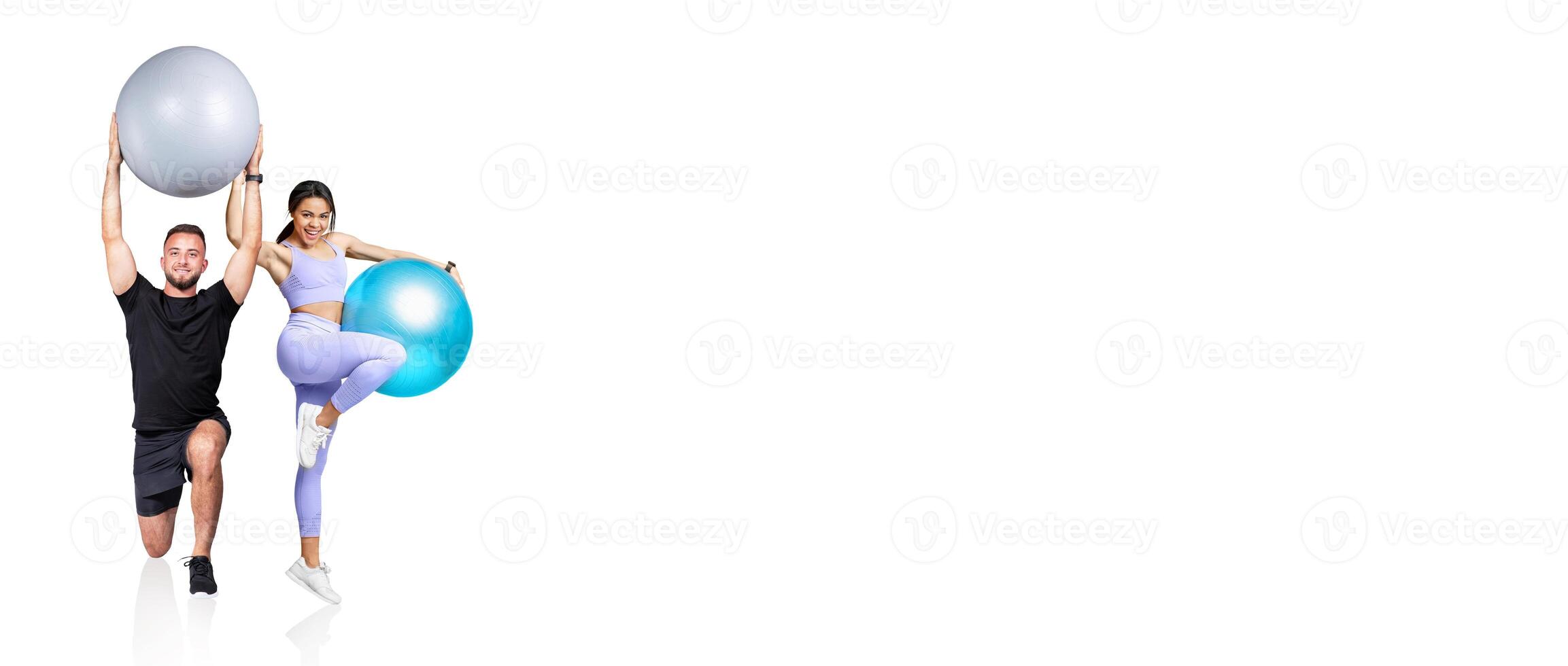 Two individuals are energetically working out with large stability balls, showcasing dynamic poses in a well-lit fitness studio. Their movements reflect enthusiasm and strength. photo