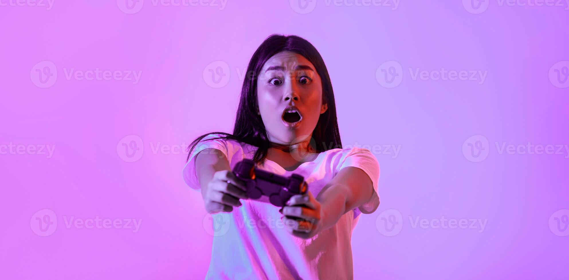 Real game. Surprised young woman with gamepad to play game photo