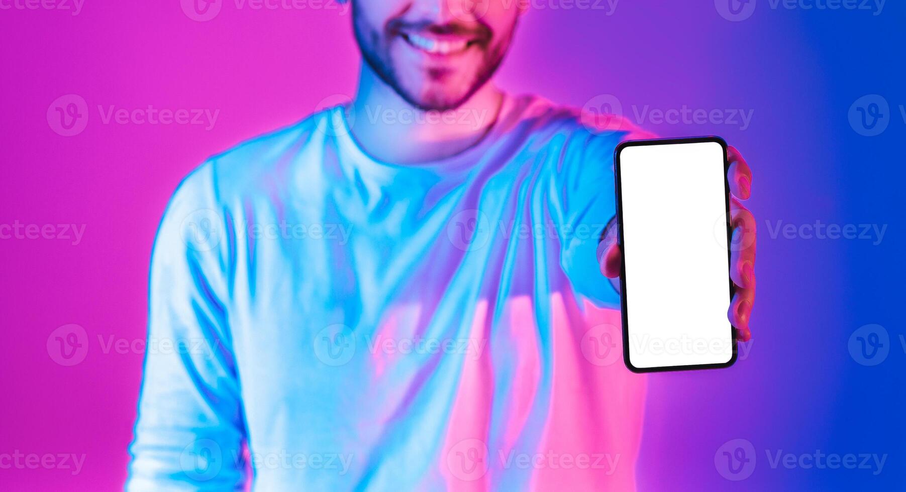 Share joy concept. Man shows smartphone with blank screen, panorama photo