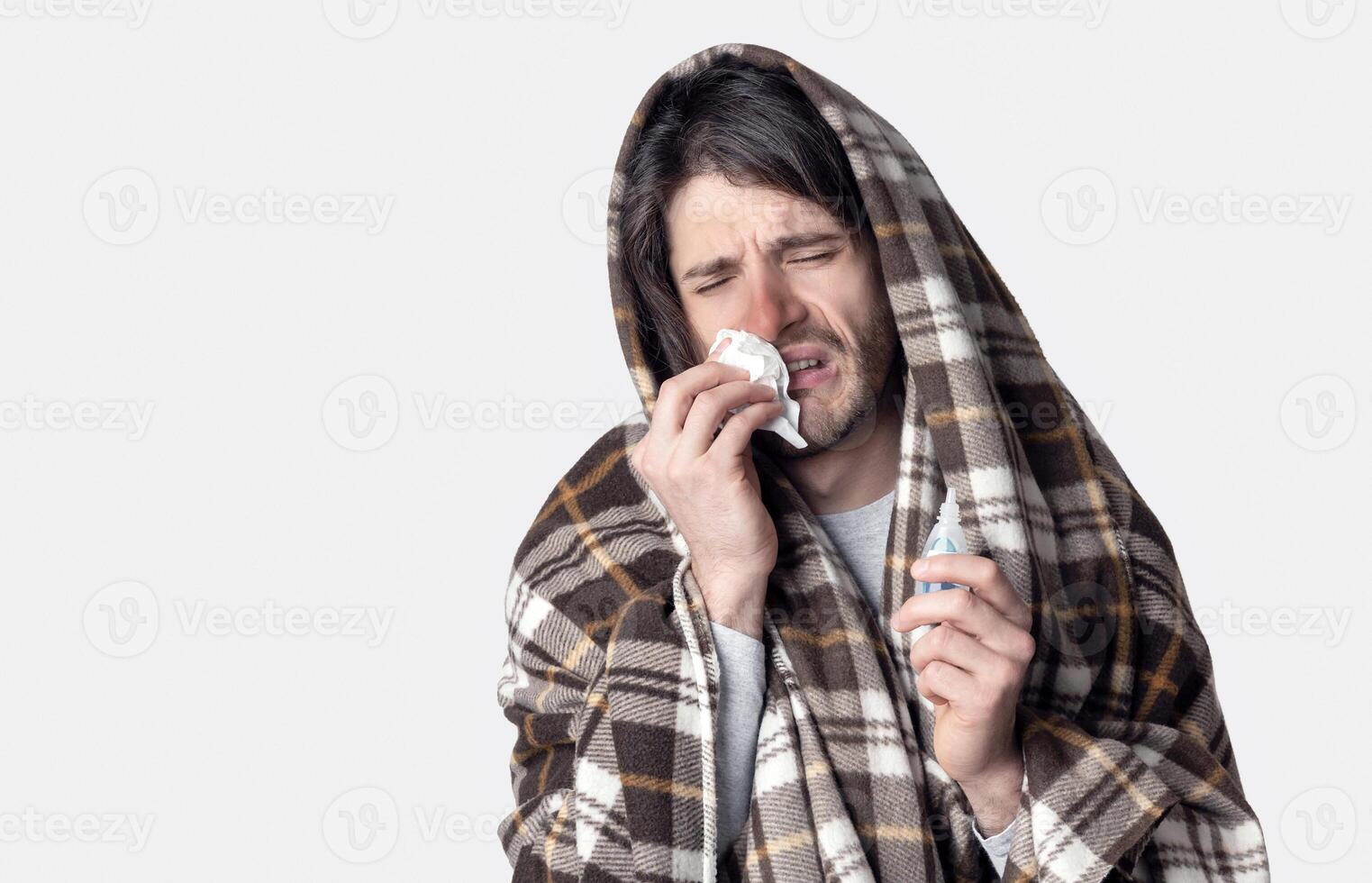 Self-isolation at illness. Guy feels bad and wipes nose with napkin photo