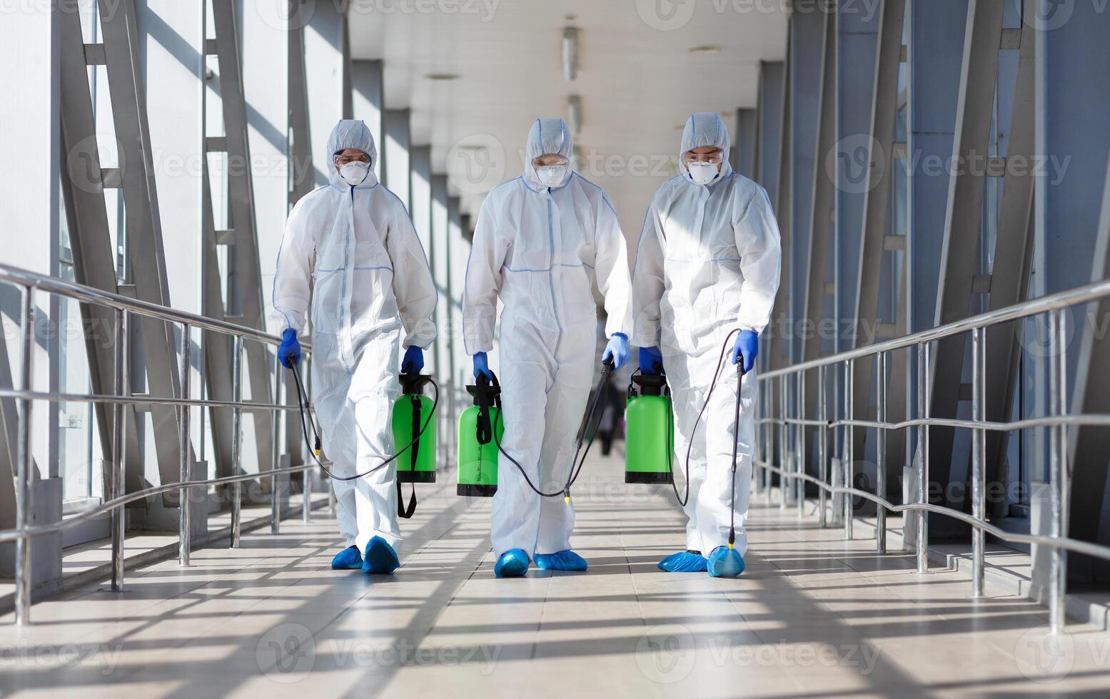 People in protective hazmat suits carrying barrels, pathogen respiratory quarantine coronavirus concept, copy space photo