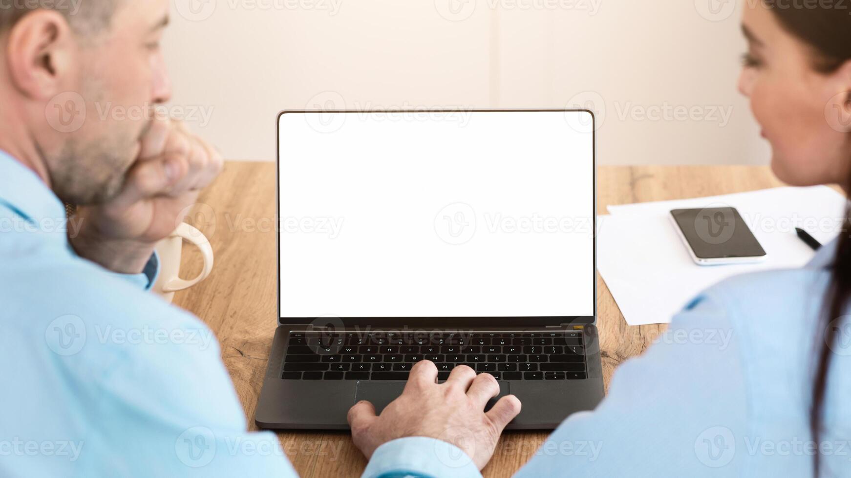 Business Colleagues At Laptop With Empty Screen Working Making Call Sitting In Modern Office. Back View, Mockup photo