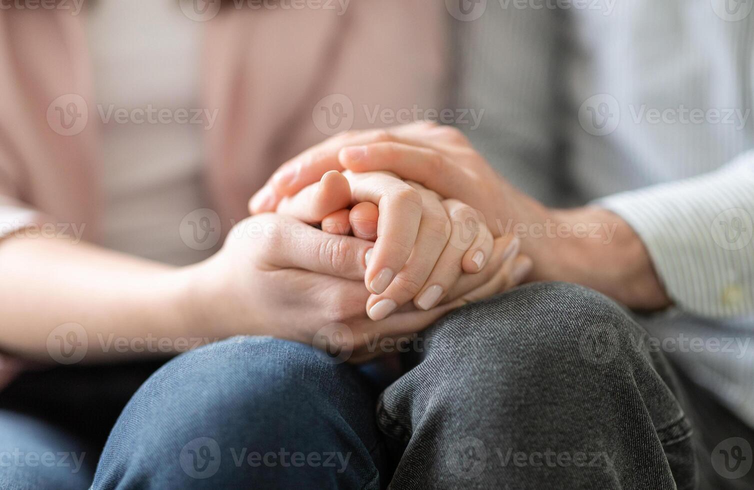 Close up of man and woman holding hands, giving psychological support photo