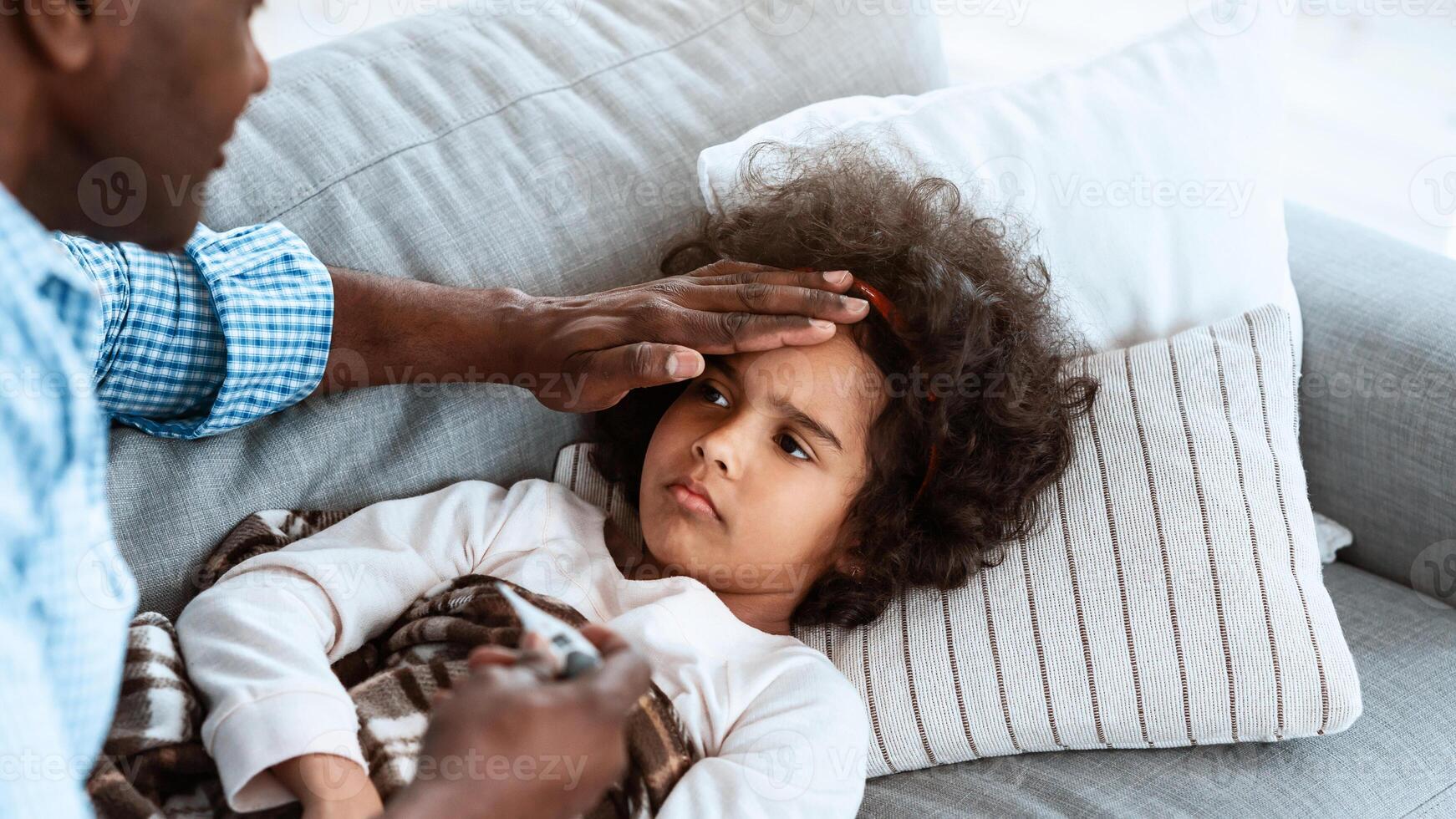 Global pandemic concept. Granddad taking care of his little granddaughter with fever at home. Blank space photo