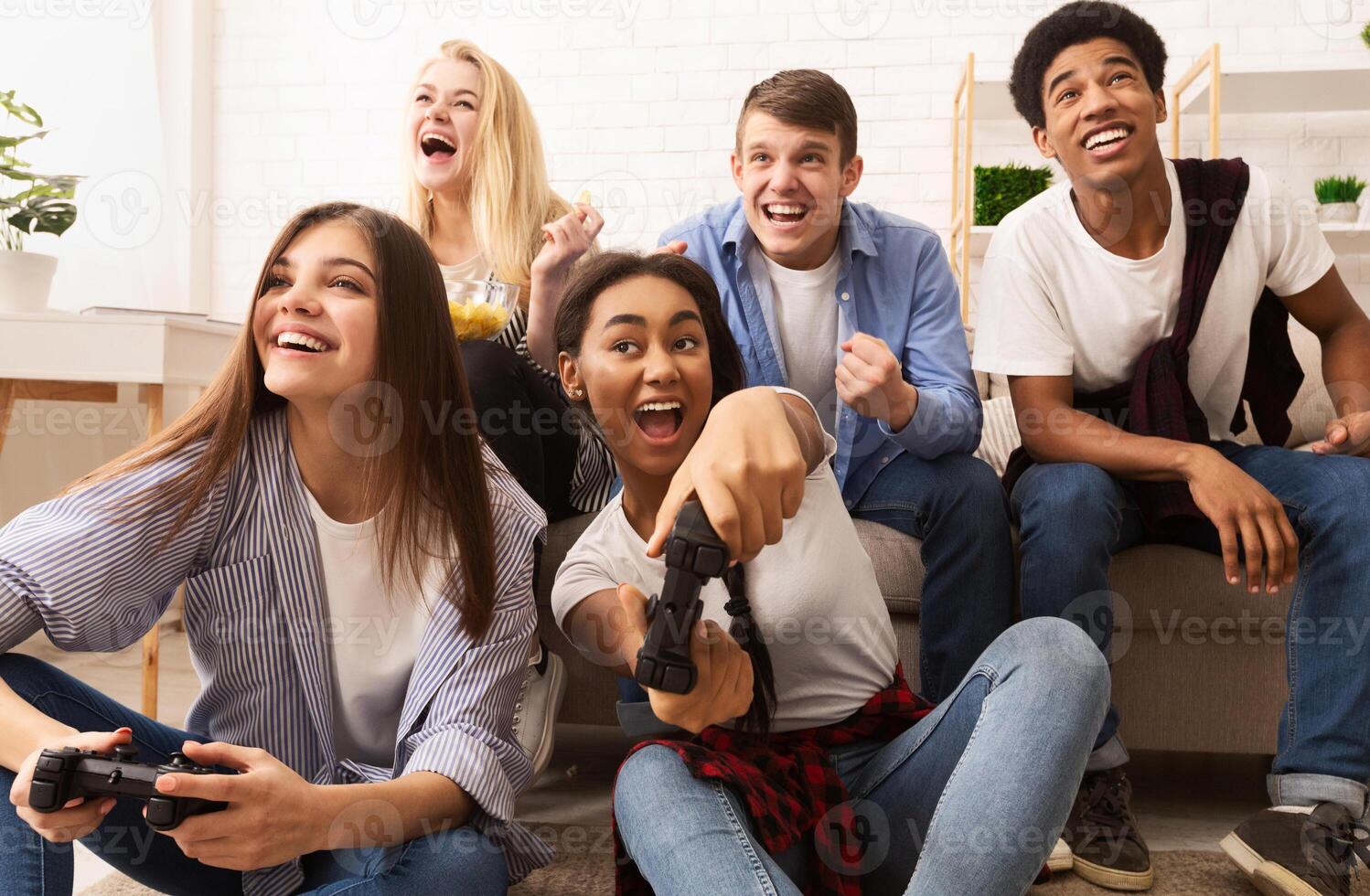 Playful diverse friends playing games online and having fun at home photo