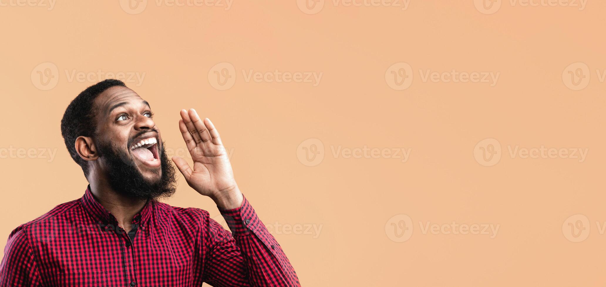 Making Announcement. Black guy holding hand near mouth, screaming aside at copy space over yellow background photo