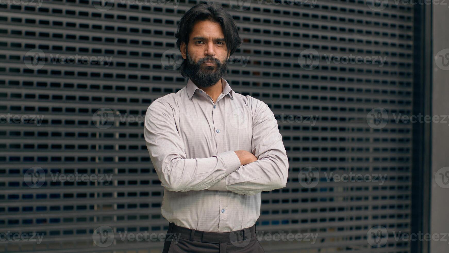 Serious concentrated confident successful bearded indian business man with glasses businessman employee manager salesman representative male entrepreneur guy assistant looking at camera posing indoors photo