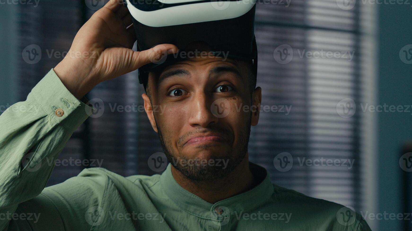 Surprised african american man take off VR glasses in 3D metaverse world play online male gamer enjoying game using virtual reality headset satisfied with modern innovative technology concept photo