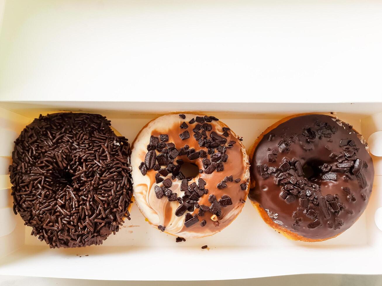 Assorted Chocolate Donuts in a Packaging Box photo