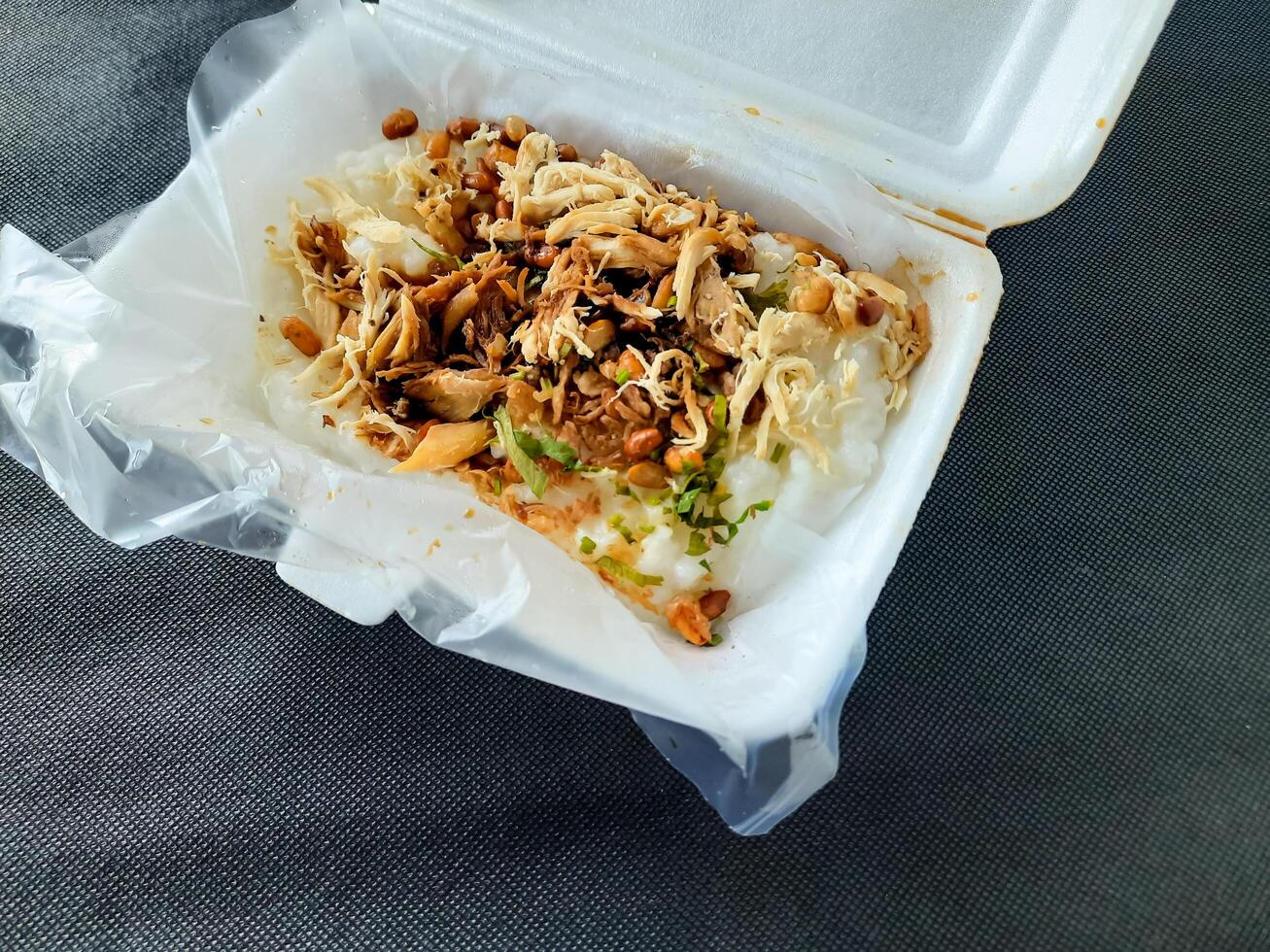 Traditional Indonesian Chicken Porridge or Bubur Ayam in a Takeaway Box photo