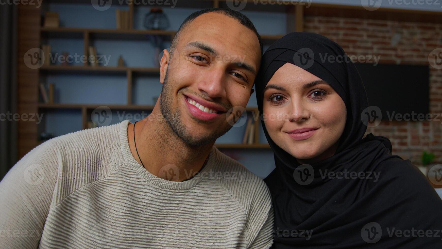 Spouses family multiracial diverse ethnicity couple man african american husband and arabian muslim woman wife smiling multiethnic girlfriend boyfriend posing together 30s happy homeowners portrait photo