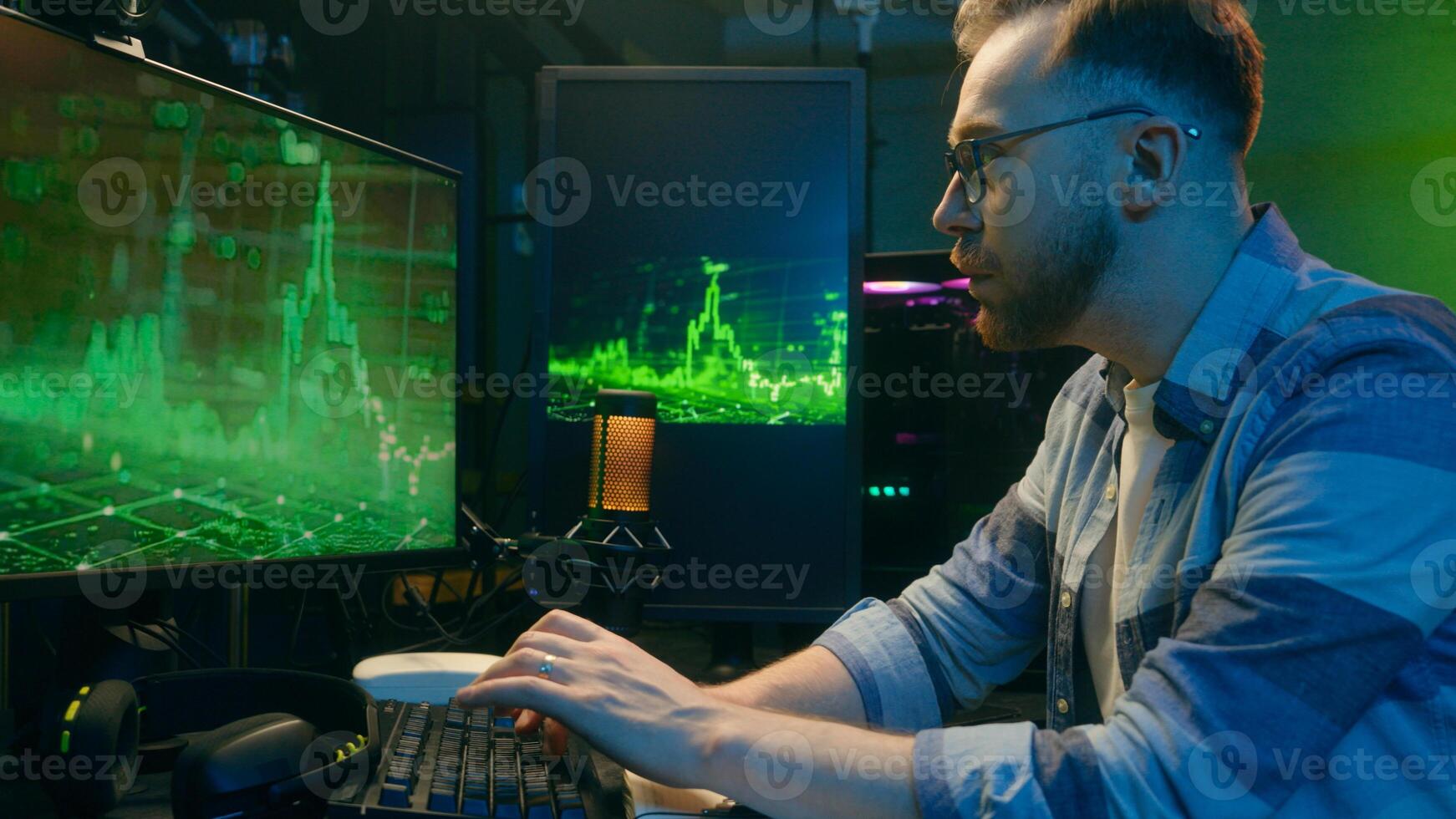 Concentrated Caucasian guy man employer businessman looking pc screen typing keyboard at home neon crypto analyst night working trading stock statistics deadline computer male freelancer overworking photo