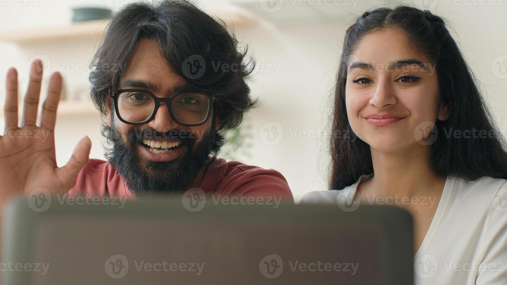Multiracial man and woman talking in computer web chat saying hello greet friends at webcam call married ethnic diverse couple chatting online in home kitchen arabian indian guy girl communicate photo