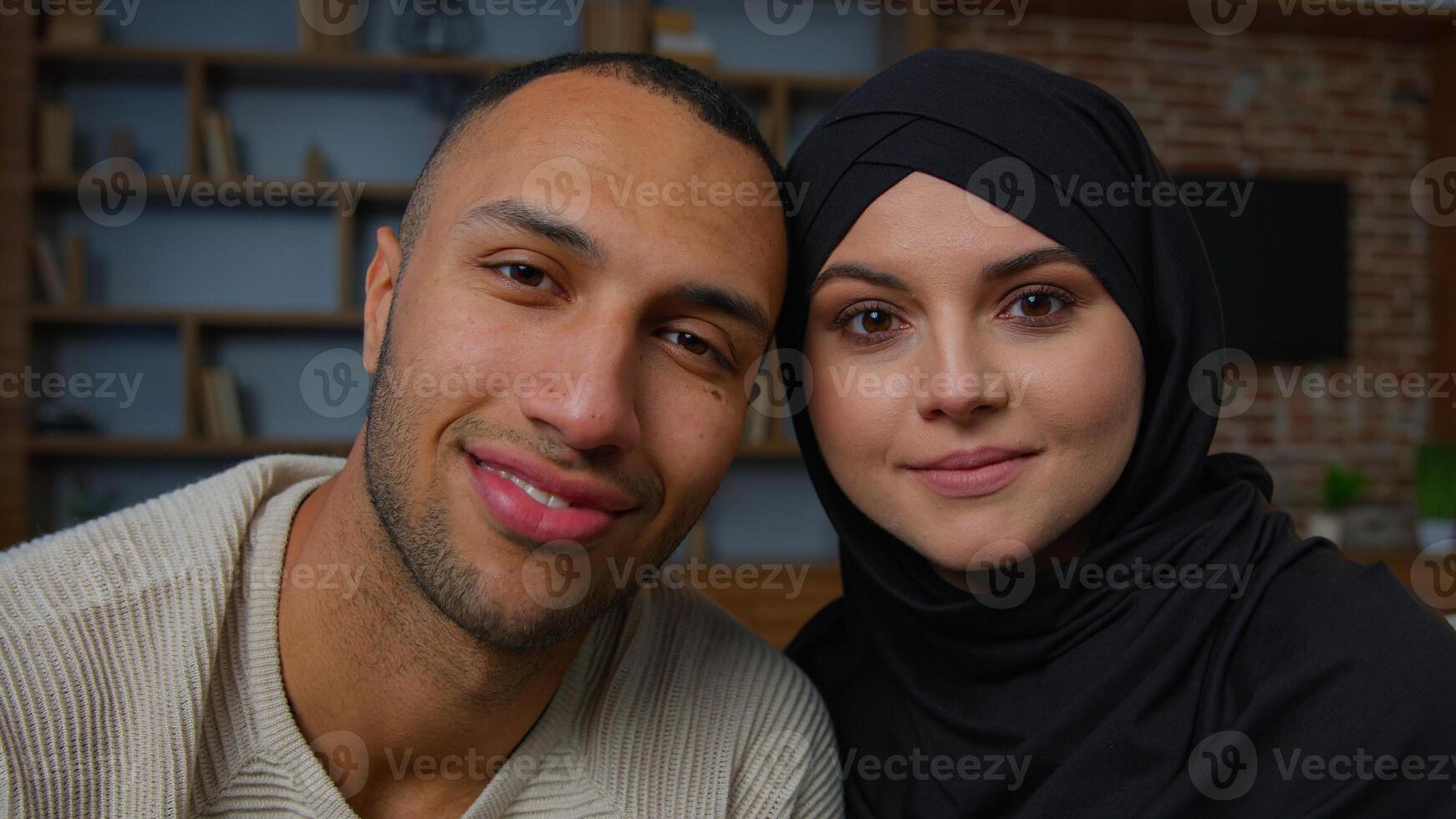 Spouses family multiracial diverse ethnicity couple man african american husband and arabian muslim woman wife smiling multiethnic girlfriend boyfriend posing together 30s happy homeowners portrait photo