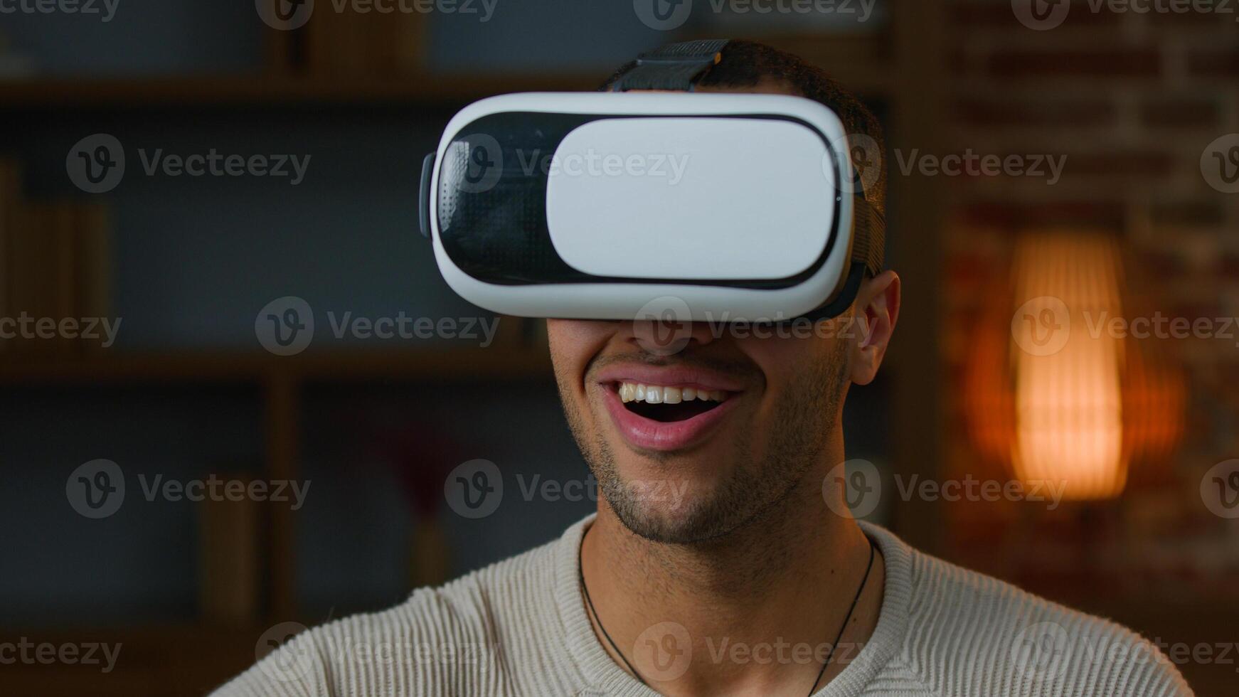 African american latino man gamer in VR goggles play game use virtual reality augmented glasses watching real simulation gaming modern 3d metaverse technology amazed ethnic millennial playing indoors photo
