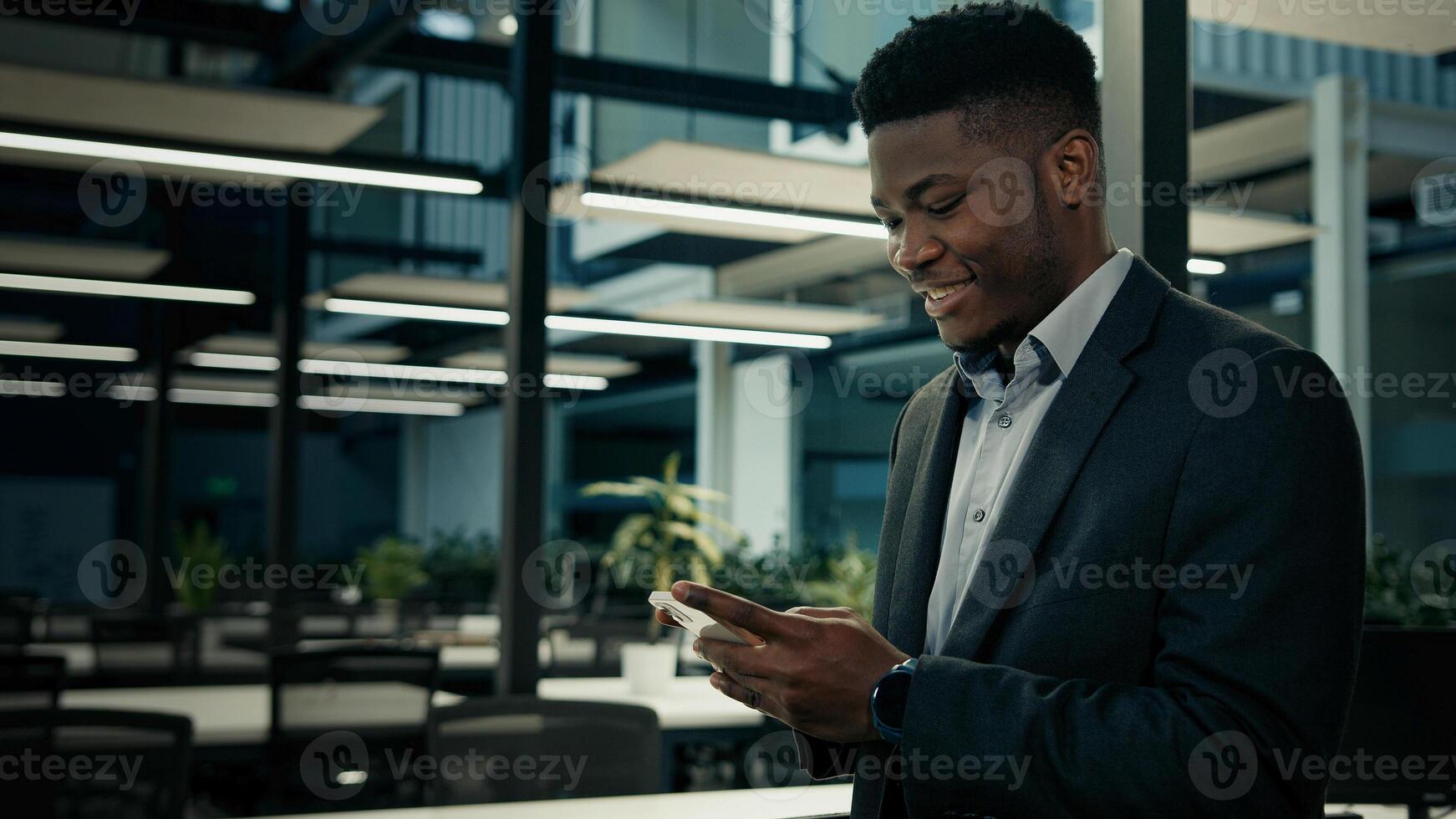 African businessman young male entrepreneur user executive worker employee ethnic man texting message on phone smiling read good mobile notification chatting online business chat cell communication photo