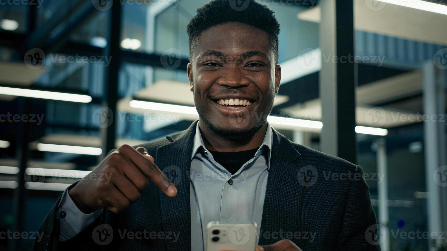 African young businessman office worker boss entrepreneur man winner work distant on phone use mobile apps send messages click on device screen win internet sales bid auction promote smartphone tech photo