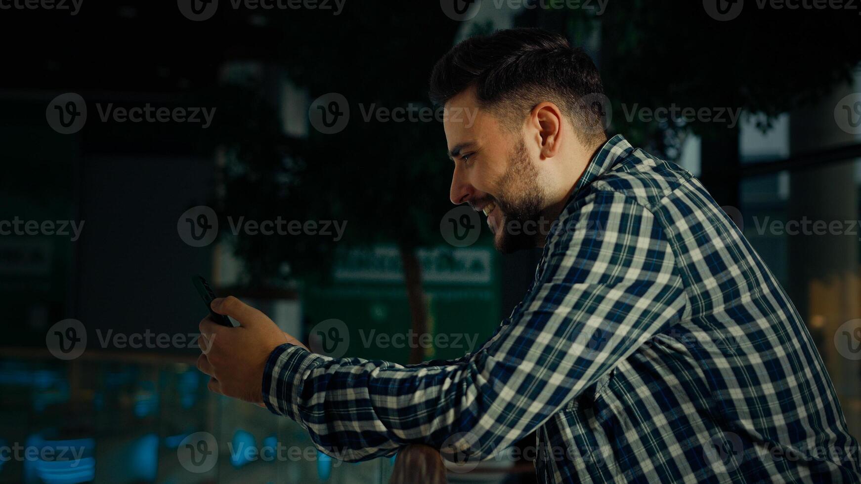Side view hispanic arabian man stand in shopping mall business center bearded handsome guy client businessman use phone gadget read digital news chatting in mobile messenger make order in online store photo