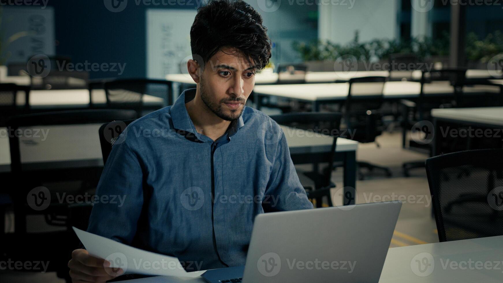 Young indian arabian businessman clerk office worker employee 30s ethnic man talk chat use computer business meeting conference app explain paper contract documentation online legal consultation photo
