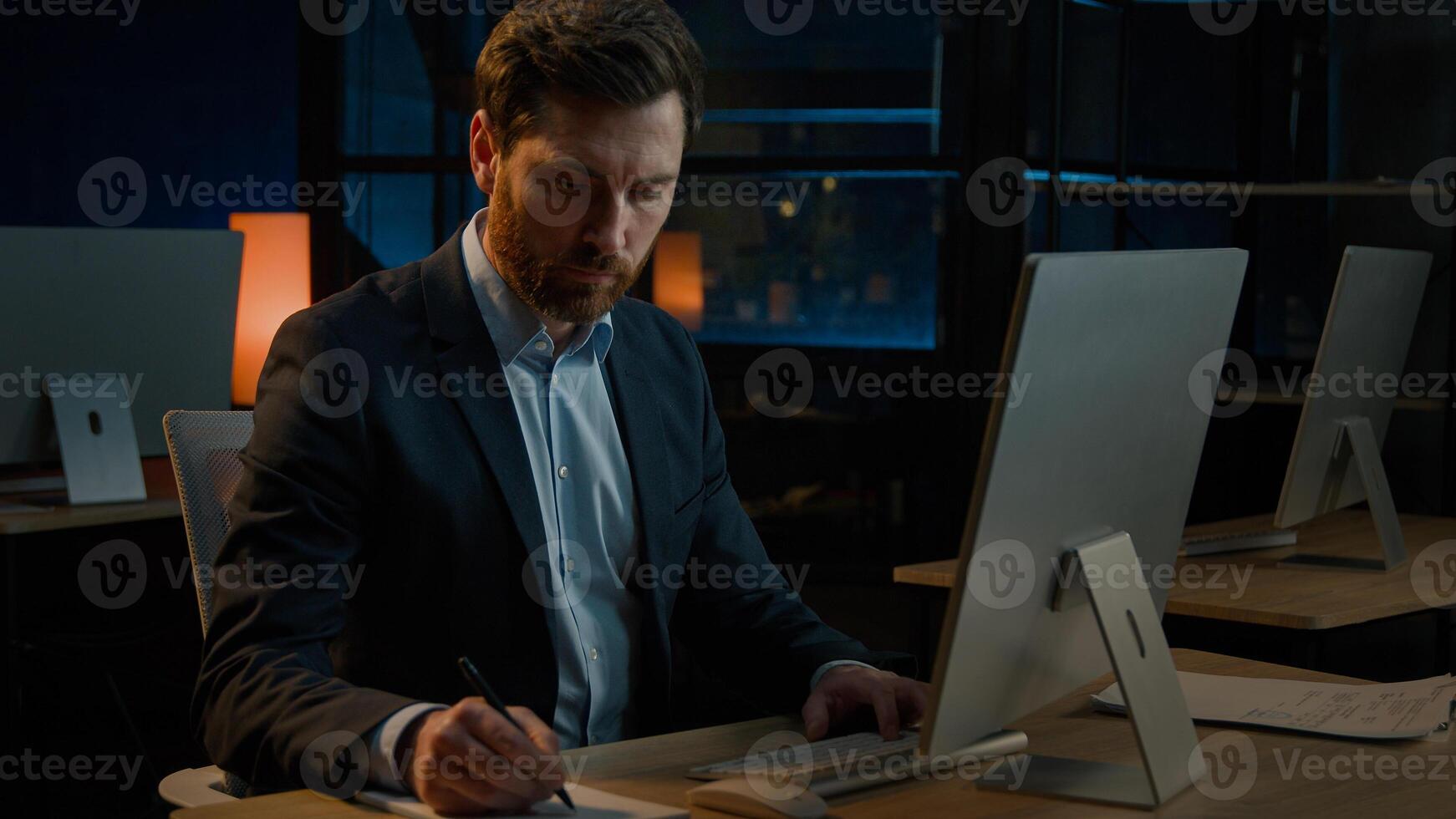 Middle-aged professional businessman Caucasian man worker male adult boss leader teacher work with papers office paperwork writing documents search data in computer online payment bills write notes photo