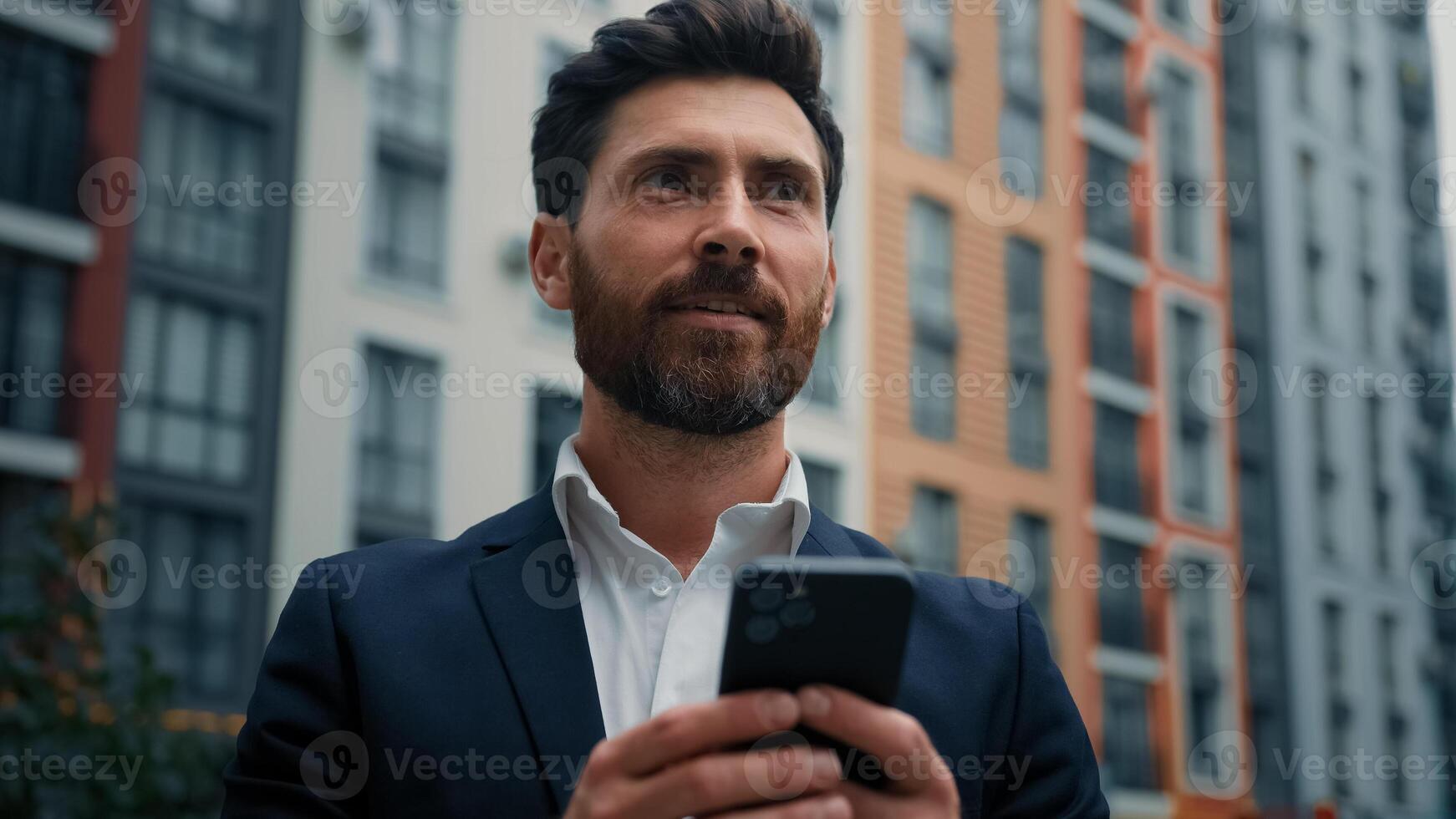 Caucasian handsome professional businessman middle-aged man hold cellphone gadget work online in city outdoor chatting on mobile phone read sms use e-banking app ecommerce modern technology concept photo