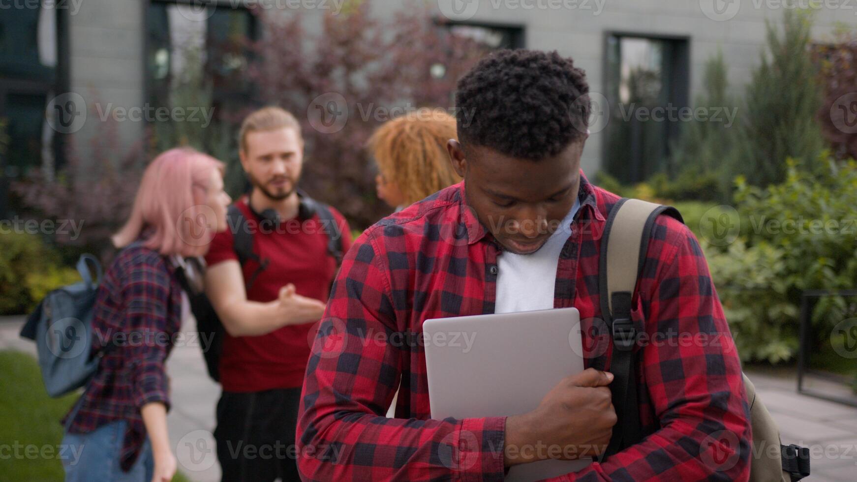 Students multiracial classmates mock humiliate bully mockery at college university outdoors discriminate showing thumbs down African American lonely man student stressed guy education studying problem photo