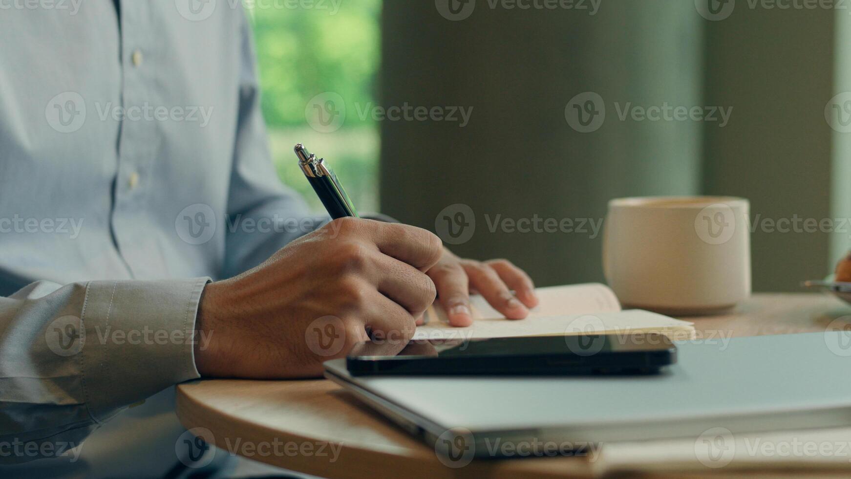 Unrecognizable man businessman writer teacher freelance worker client visitor student write notes business tasks on table cafe male guy study learn writing data in notebook drink coffee in restaurant photo