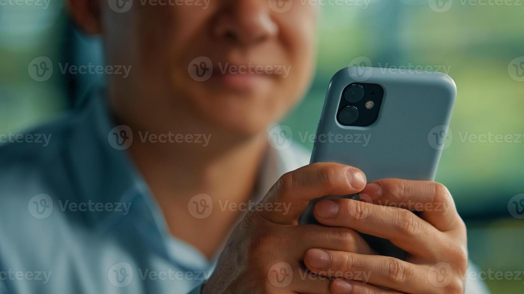 Unknown asian man businessman worker modern user senior entrepreneur hold in hands phone search online information use mobile business apps wifi 5g connection in office texting messages on smartphone photo