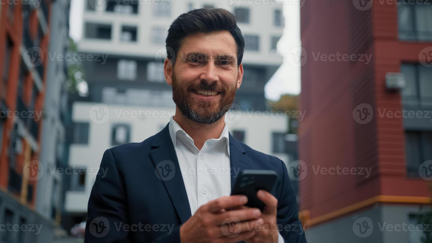 Caucasian handsome professional businessman middle-aged man hold cellphone gadget work online in city outdoor chatting on mobile phone read sms use e-banking app ecommerce modern technology concept photo