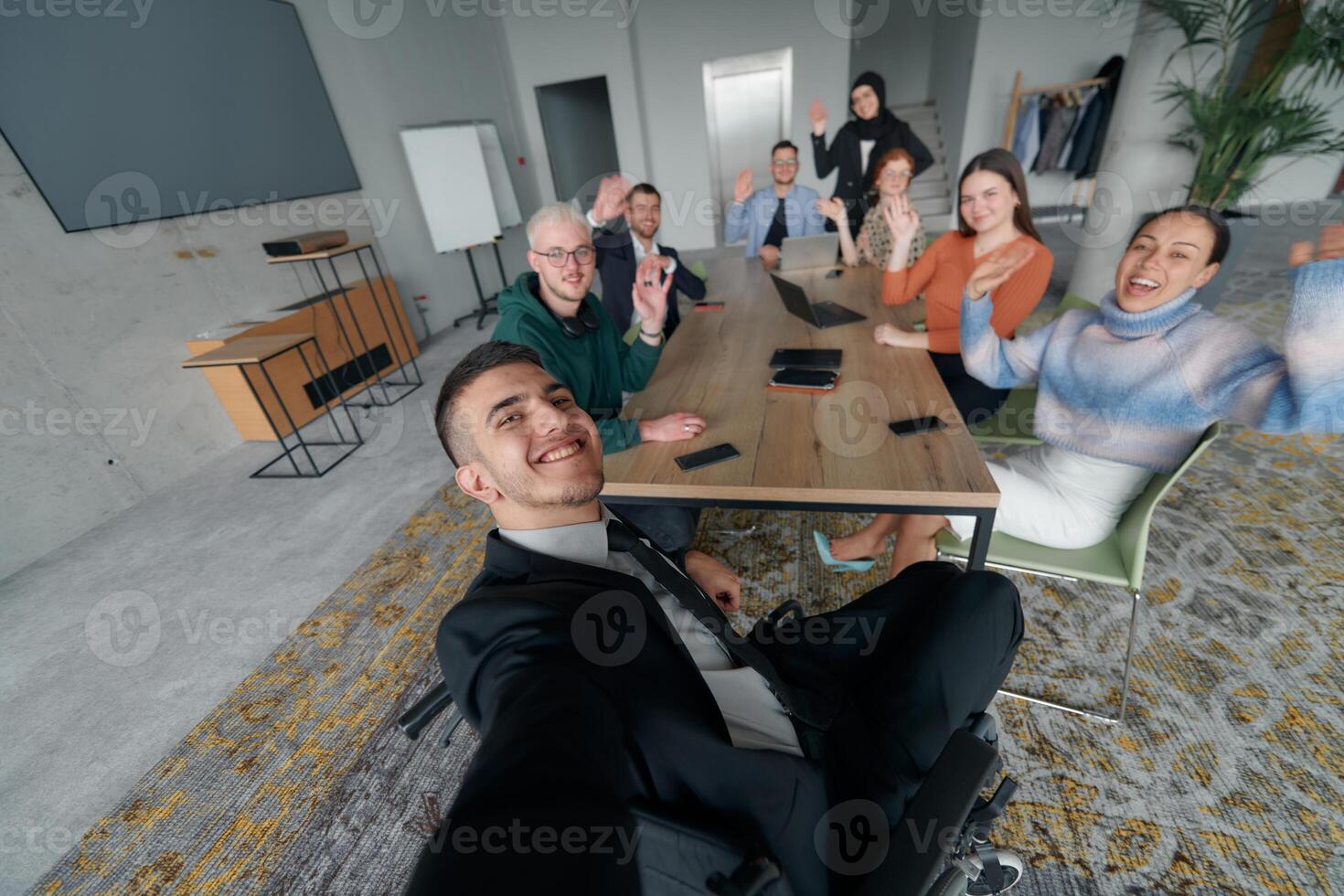 A group of business professionals taking a selfie during a break in an office meeting, capturing a moment of teamwork and collaboration in a modern workplace photo
