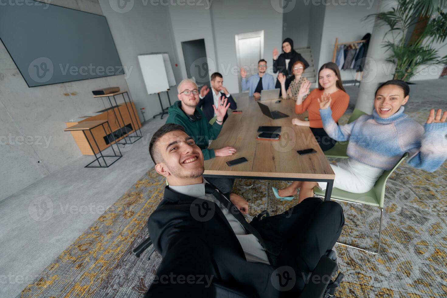 A group of business professionals taking a selfie during a break in an office meeting, capturing a moment of teamwork and collaboration in a modern workplace photo