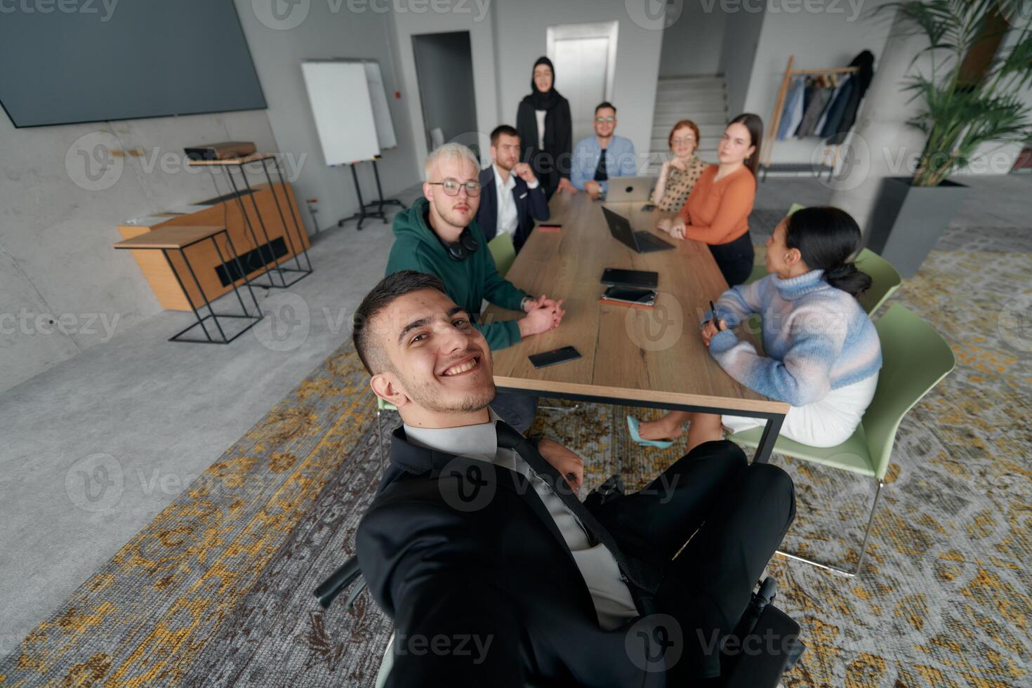 A group of business professionals taking a selfie during a break in an office meeting, capturing a moment of teamwork and collaboration in a modern workplace photo