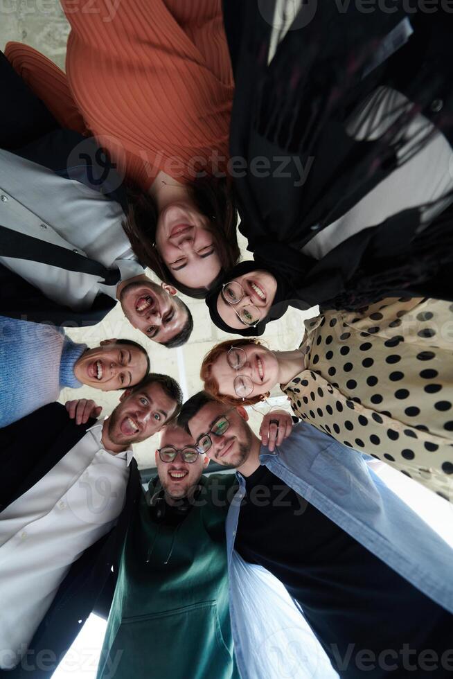 A diverse group of business professionals standing together in a powerful, united pose, captured from a low-angle perspective, exuding confidence and teamwork photo