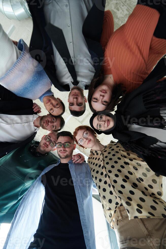 A diverse group of business professionals standing together in a powerful, united pose, captured from a low-angle perspective, exuding confidence and teamwork photo