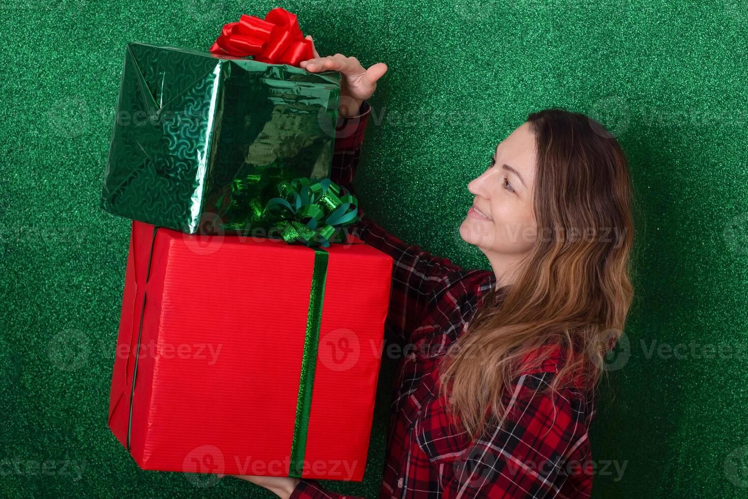 smiling woman with a large gift in his hands on a green background. holiday. New Year. Valentine's Day photo
