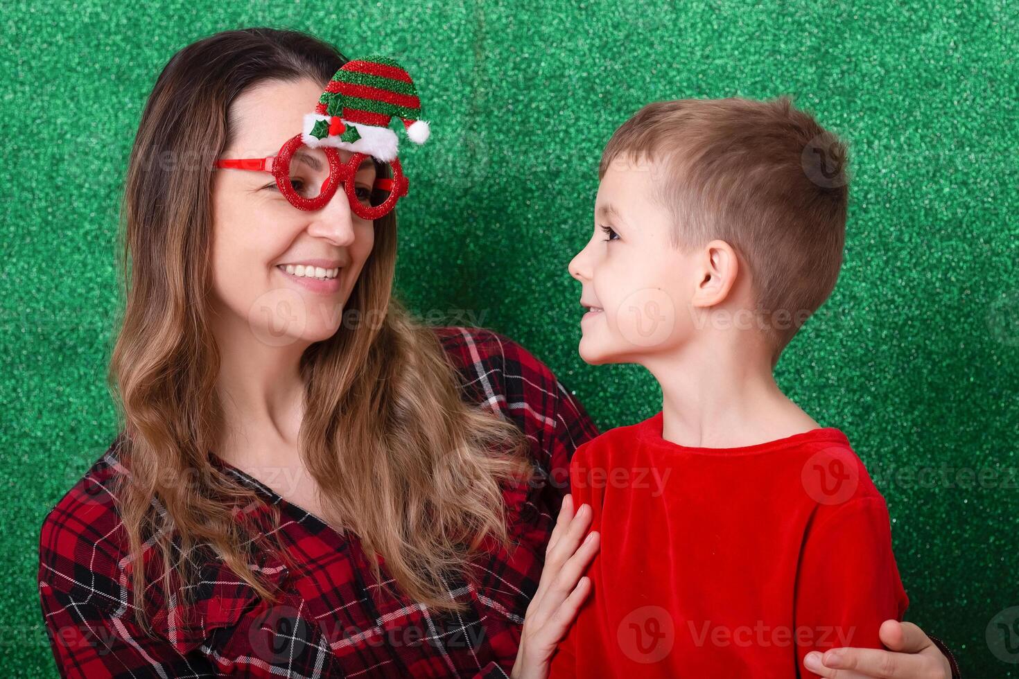 mother and son are preparing for Christmas and New Year. child plays with mom at Christmas. family celebration. green background photo