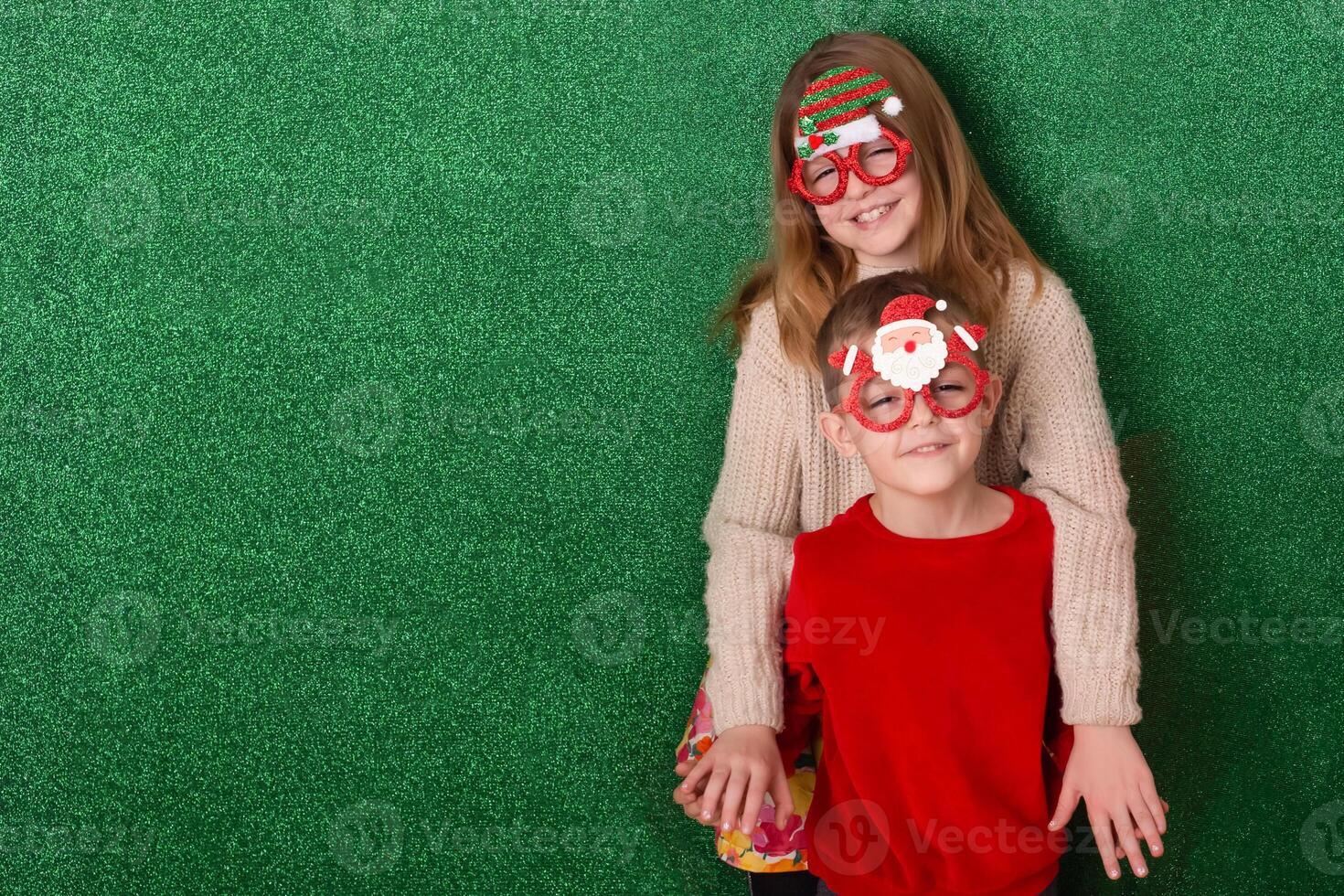 happy children on a green background. children rejoice at the holiday. new year in the family. friendly children enjoy gifts and holidays photo