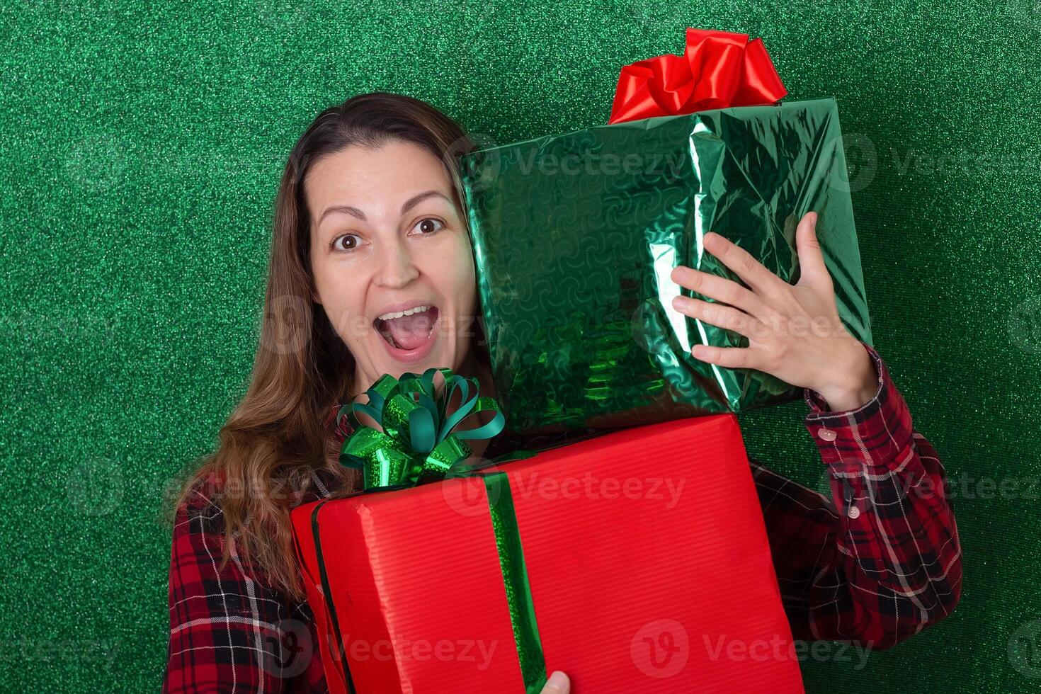 smiling woman with a large gift in his hands on a green background. holiday. New Year. Valentine's Day photo