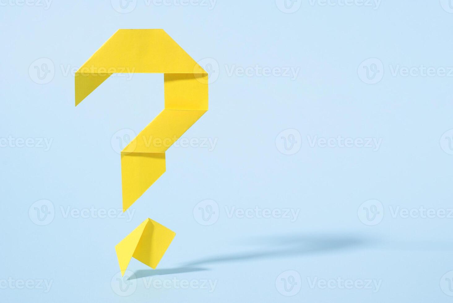 Floating yellow origami question mark with drop shadow photo