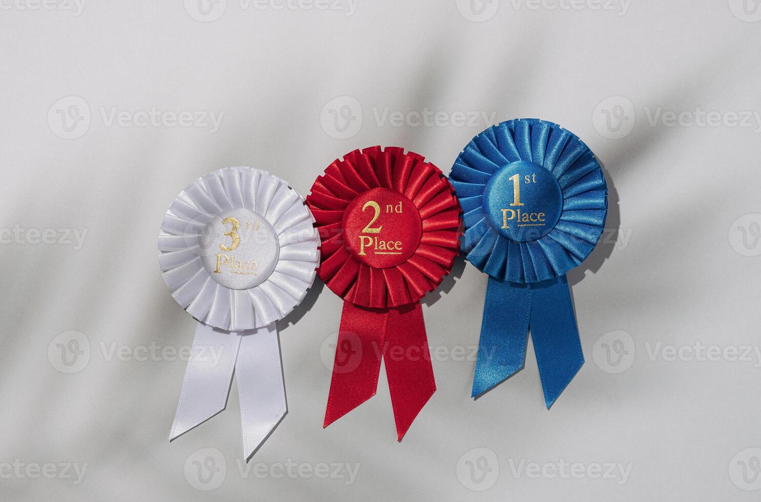 Winner success trending concept. Three rosette on a gray background and the shadow of a palm tree. photo