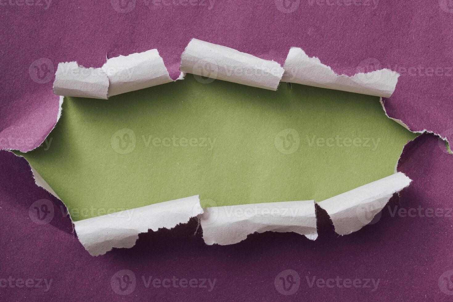Ripped or torn purple paper frame with green copy space photo