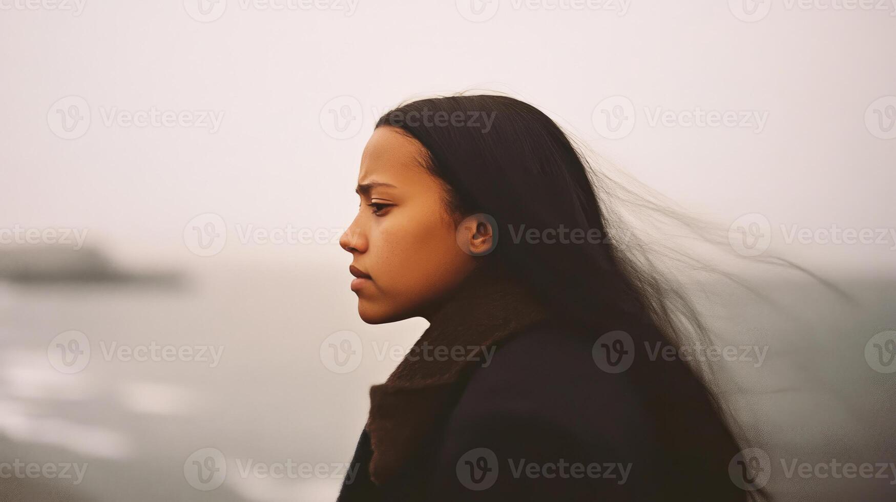 Pensive woman gazes at the ocean photo